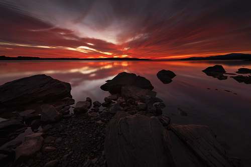 ashokan reservoir rocks in body of water during golden hour dawn